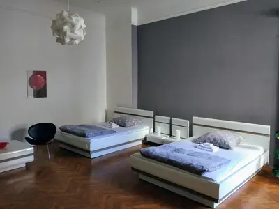 two twin beds in a room with wood floors at Apartments Týnská 7 in Prague