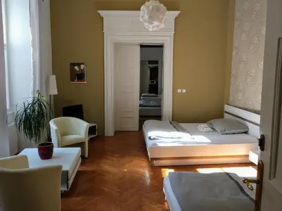 a room with two beds and a chair in it at Apartments Týnská 7 in Prague
