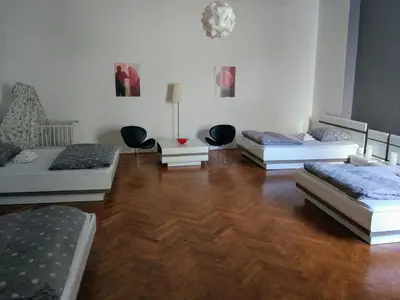 three beds in a room with wooden floors at Apartments Týnská 7 in Prague