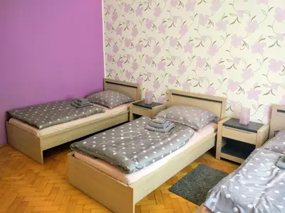 two twin beds in a room with purple walls at Apartments Týnská 7 in Prague