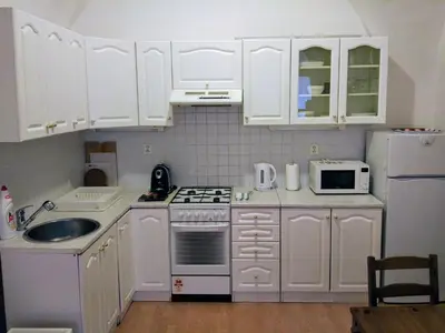 a kitchen with white cabinets and a sink and a refrigerator at Apartments Týnská 7 in Prague