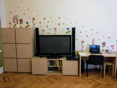 a living room with a tv and a desk and a table with a laptop at Apartments Týnská 7 in Prague