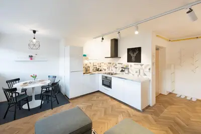 a kitchen and living room with a table and chairs at Veleslavin Apartments in Prague