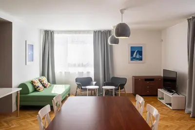 a living room with a table and a green couch at Veleslavin Apartments in Prague