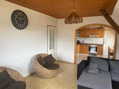 a living room with a couch and a clock on the wall at Runch Smilovice in Chotilsko