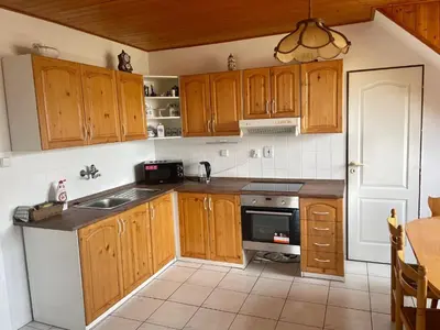 a kitchen with wooden cabinets and a sink and a stove at Runch Smilovice in Chotilsko