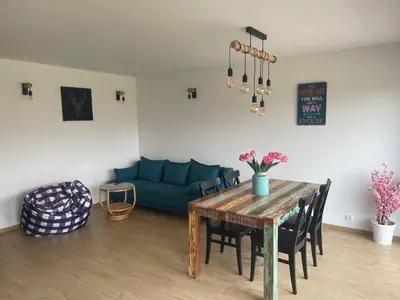 a living room with a table and a blue couch at Runch Smilovice in Chotilsko