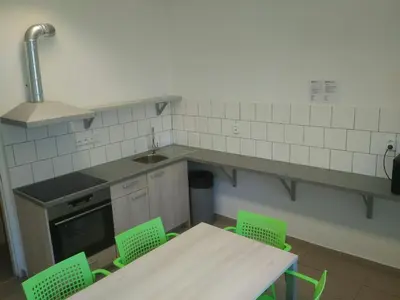 a kitchen with green chairs and a table and a sink at Volha in Prague