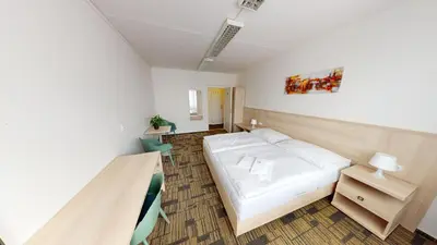 a bedroom with a white bed and a table at Volha in Prague