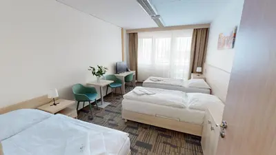 a hotel room with two beds and a desk at Volha in Prague