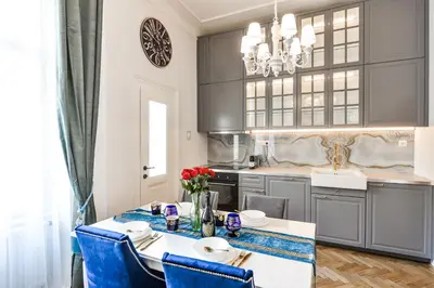 a kitchen with a dining table and blue chairs at Glamour Frida apartment in Prague
