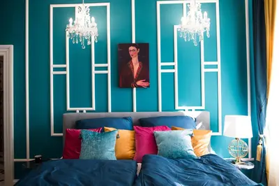 a bedroom with blue walls and a bed with colorful pillows at Glamour Frida apartment in Prague