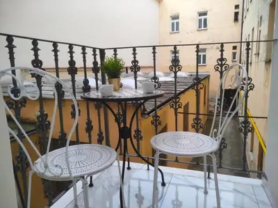 two chairs and a table on a balcony at Glamour Frida apartment in Prague