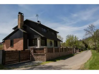 a brick house with a fence next to a dirt road at CHATA Privlaky in Přívlaky