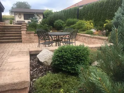 a patio with a table and chairs in a garden at CHATA Privlaky in Přívlaky