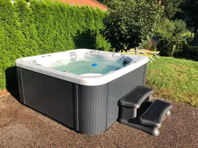 a large hot tub with two chairs in a yard at CHATA Privlaky in Přívlaky