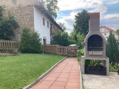 a backyard with a pizza oven next to a house at Kamenný dům Bezdědice-Máchův kraj in Bezdědice