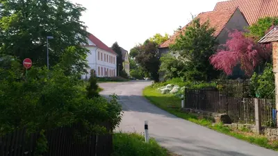 an empty street in a residential neighborhood with a stop sign at Kamenný dům Bezdědice-Máchův kraj in Bezdědice