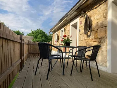 a patio with two chairs and a table on a deck at Kamenný dům Bezdědice-Máchův kraj in Bezdědice