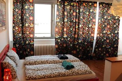 a bedroom with two beds and a window with curtains at Panorama Prague Castle with Terrace in Prague