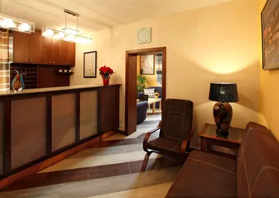 a living room with a table and chairs and a tv at Anyday Apartments in Prague