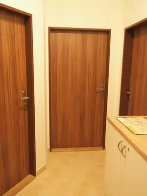 two wooden doors in a room with a kitchen at Museum Inn in Prague