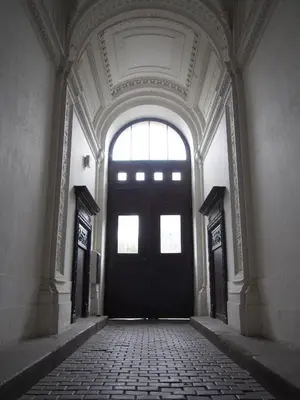 an empty hallway with a black door and a window at Museum Inn in Prague