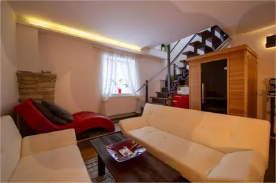 a living room with a white couch and a red chair at Apartmány Ztracená in Roudnice nad Labem