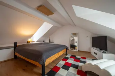 a bedroom with a bed and a flat screen tv at Apartmány Ztracená in Roudnice nad Labem