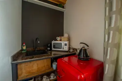 a small kitchen with a microwave and a red refrigerator at Apartmány Ztracená in Roudnice nad Labem