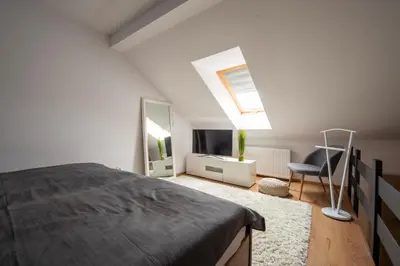 a bedroom with a bed and a window and a chair at Apartmány Ztracená in Roudnice nad Labem
