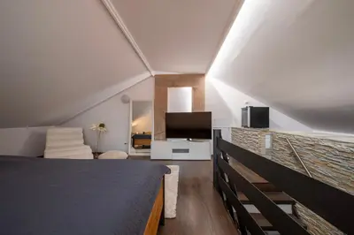 a bedroom with a bed and a flat screen tv at Apartmány Ztracená in Roudnice nad Labem