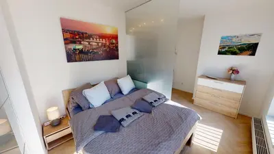 a small bedroom with a bed with blue pillows at ONSITE Free Garage Parking, 10min Centre by Bus in Prague