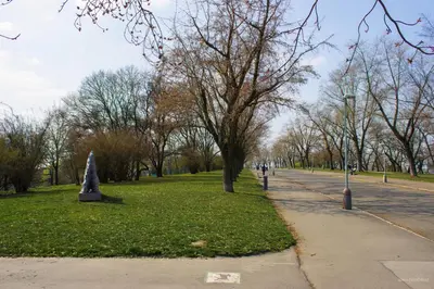 a park with a tree in the grass and a sidewalk at ONSITE Free Garage Parking, 10min Centre by Bus in Prague