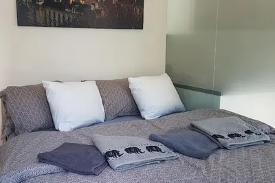 a bed with towels and pillows on top of it at ONSITE Free Garage Parking, 10min Centre by Bus in Prague