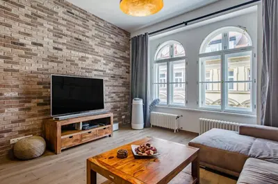 a living room with a tv and a brick wall at Luxury apartment at Prague city centre Anděl! in Prague