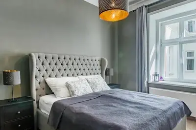 a bedroom with a bed with a blue blanket and a window at Luxury apartment at Prague city centre Anděl! in Prague