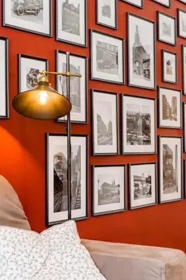 a wall of pictures on a wall with a lamp at Luxury apartment at Prague city centre Anděl! in Prague
