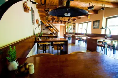 a restaurant with wooden tables and chairs and a bar at Motel Svatý Kryštof in Liběchov