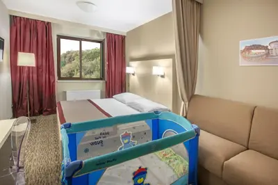 a small room with a bed and a couch at Hotel Hartig in Prague