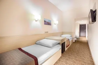 a small room with a bed and a tv at Hotel Hartig in Prague