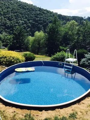 a large blue pool with a chair at Summer lake in Chotilsko