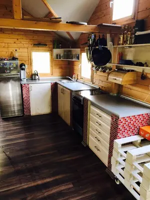 a large kitchen with wooden walls and wooden floors at Summer lake in Chotilsko