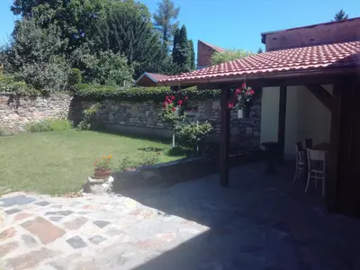a backyard with a stone wall and a pergola at Penzion Na Letním bytě in Kouřim