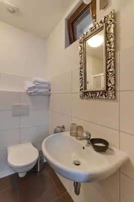 a bathroom with a sink and a toilet and a mirror at Penzion Na Letním bytě in Kouřim