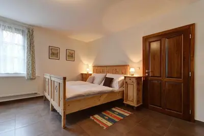 a bedroom with a wooden bed and a window at Penzion Na Letním bytě in Kouřim