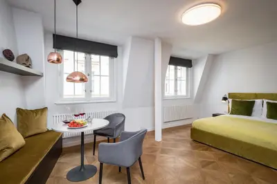 a hotel room with a bed and a table and chairs at Exclusive Old Town residence near Charles Bridge in Prague