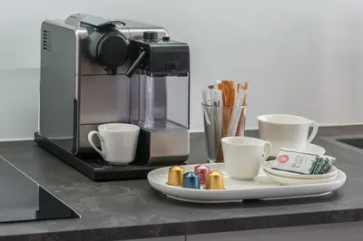 a coffee maker and a plate with cups on a counter at Exclusive Old Town residence near Charles Bridge in Prague