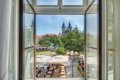 an open window with a view of a castle at Mikulášská - Old Town Square View Residence in Prague