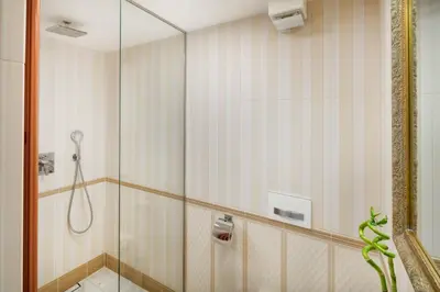 a bathroom with a shower with a glass door at Mikulášská - Old Town Square View Residence in Prague